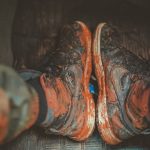 Close-up of muddy boots inside a vehicle, capturing the essence of adventure and rugged outdoor lifestyle.