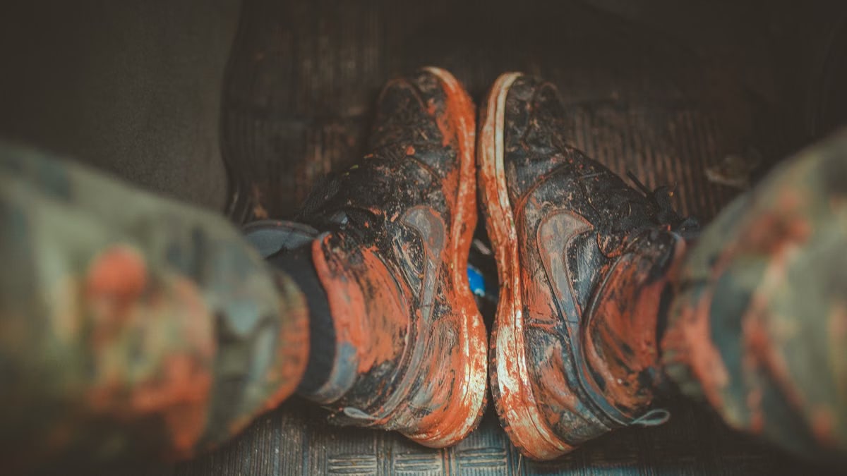 Close-up of muddy boots inside a vehicle, capturing the essence of adventure and rugged outdoor lifestyle.
